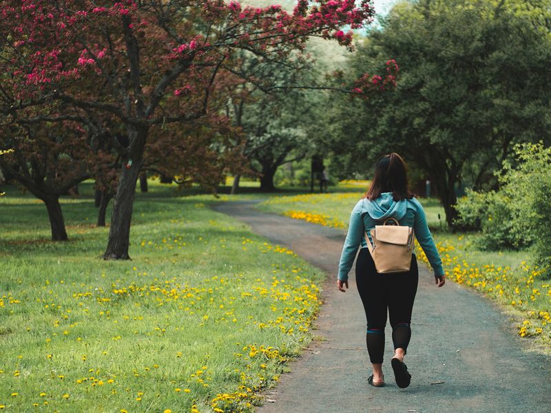 Woman walking on a park path in spring