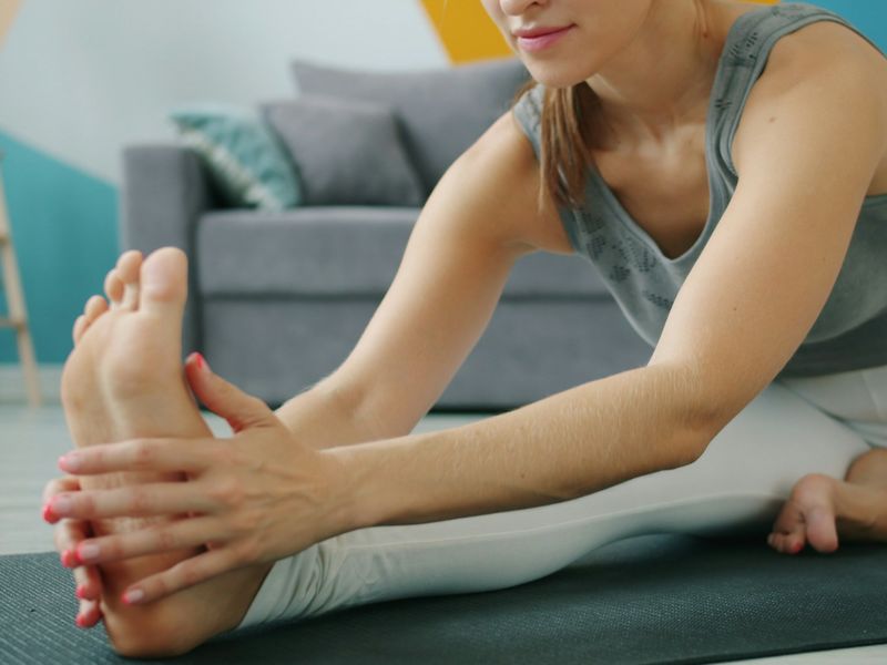 Woman reaching for her toes in a seated stretch